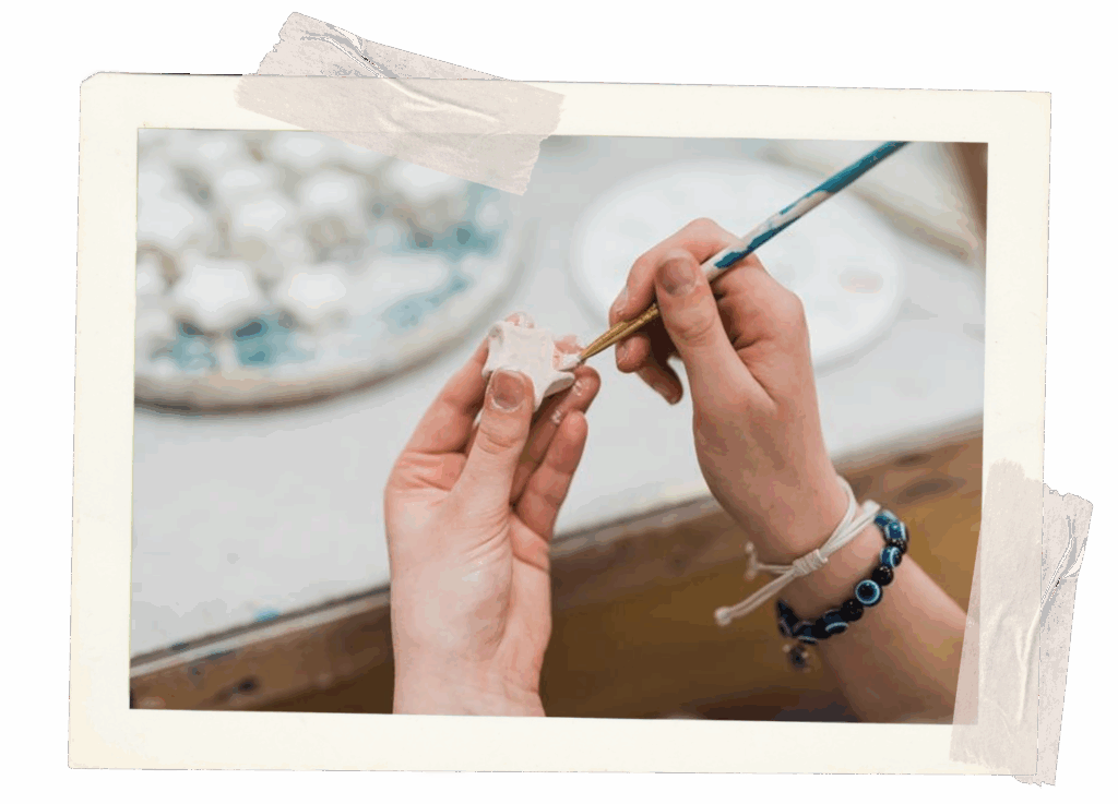 Someone doing ceramics, appears to be painting the clay.